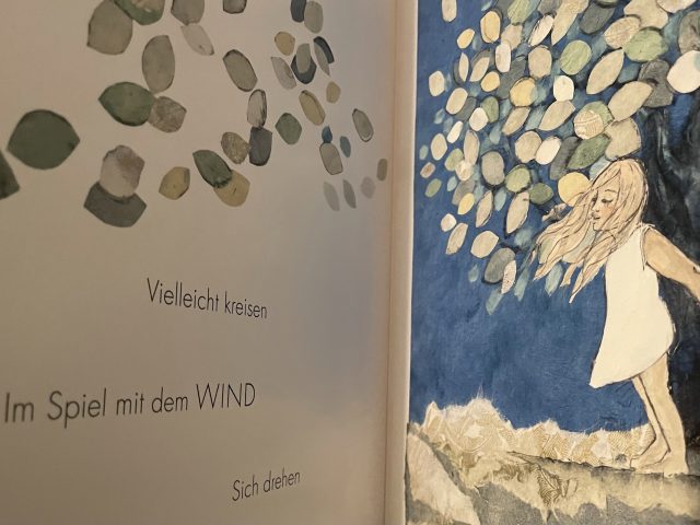 Innenansicht des Buches Windkind mit vier Zeilen auf der linken Seite und einem Bild auf der rechten Seite 