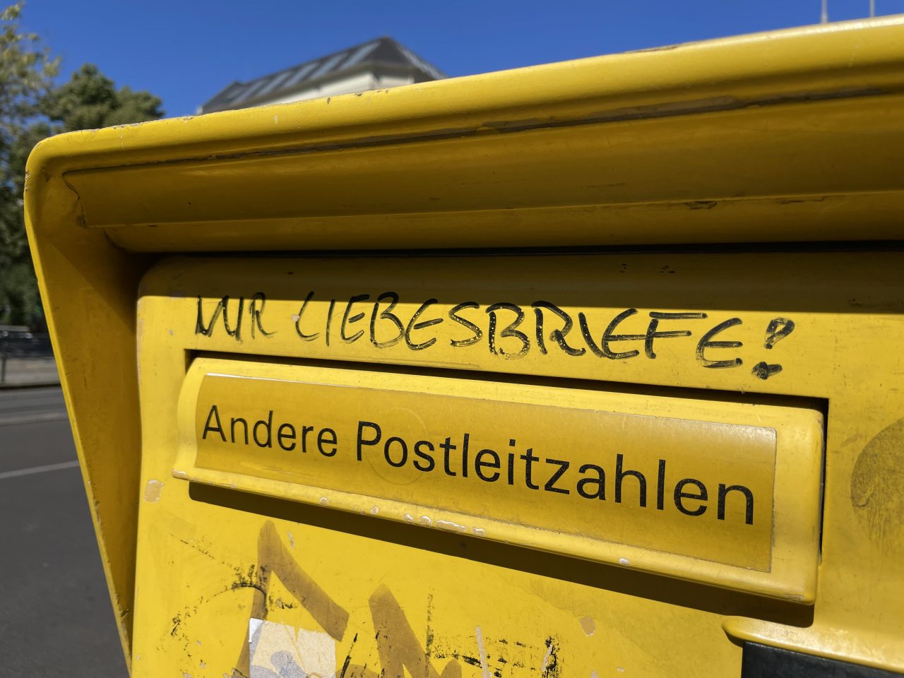 gelber Briefkasten an der Straße - über der Einwurfmöglichkeit "Andere Postleitzahlen" steht "Nur Liebesbriefe!"