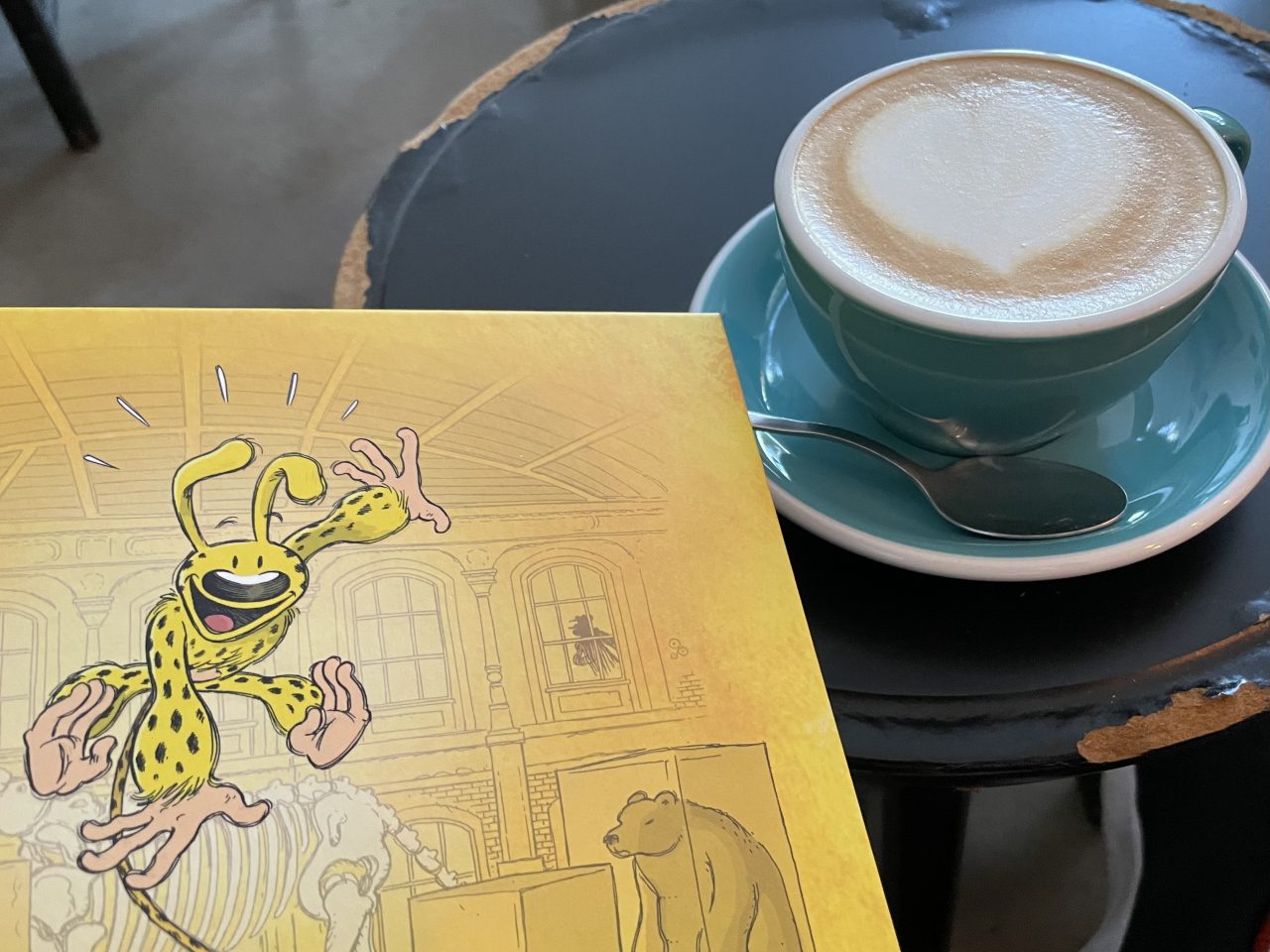 ein Marsupilami-Abenteuer Comic neben einem Kaffee auf einem Tisch