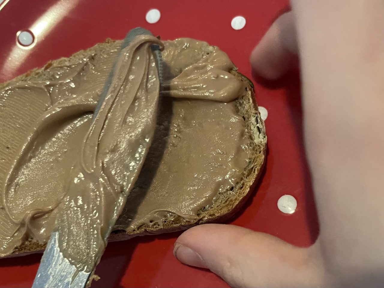 Brot, dass mit Schokolade bestrichen wird