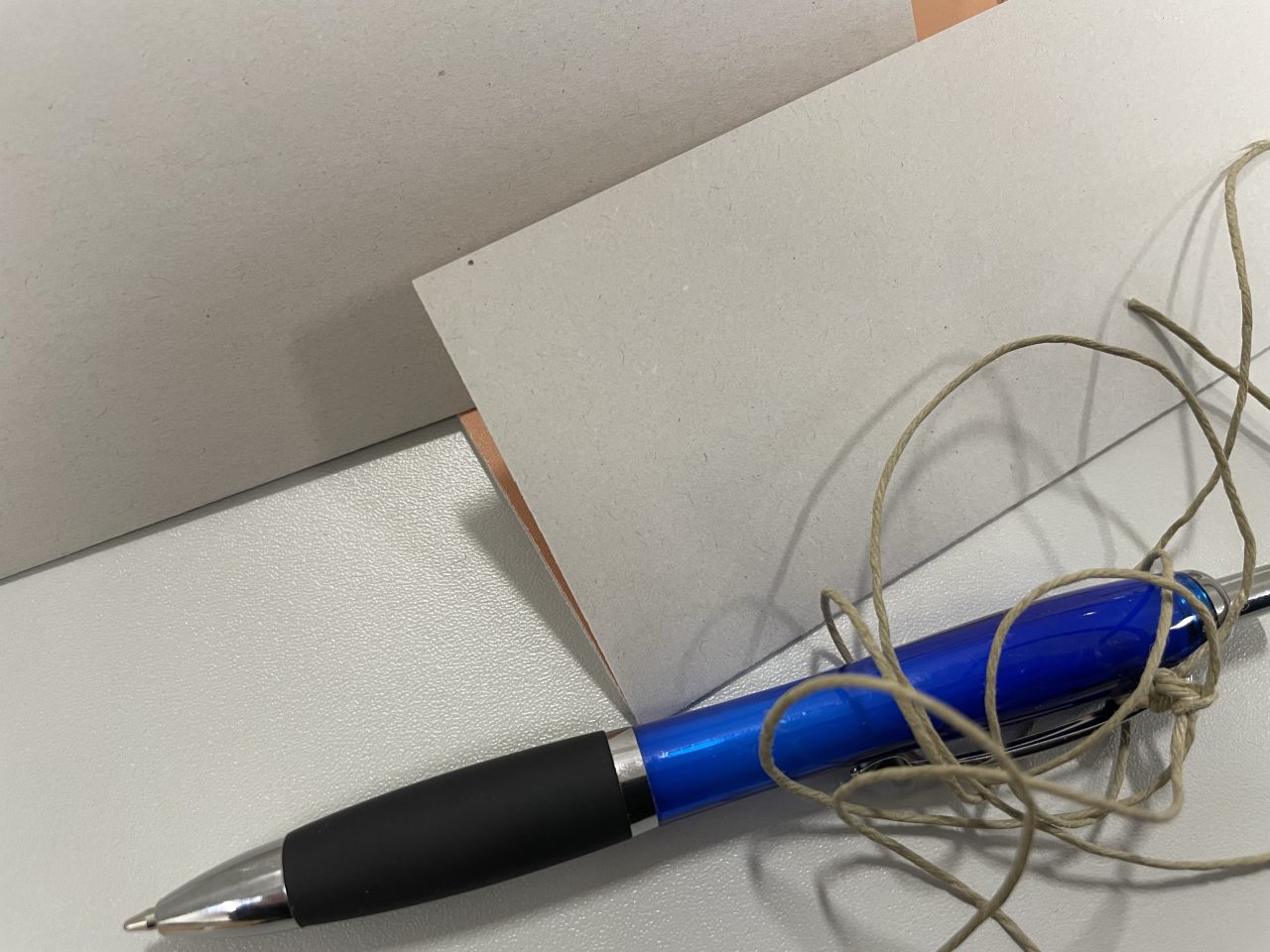 gefaltete Wahlzettel mit einem angebundenen Kugelschreiber