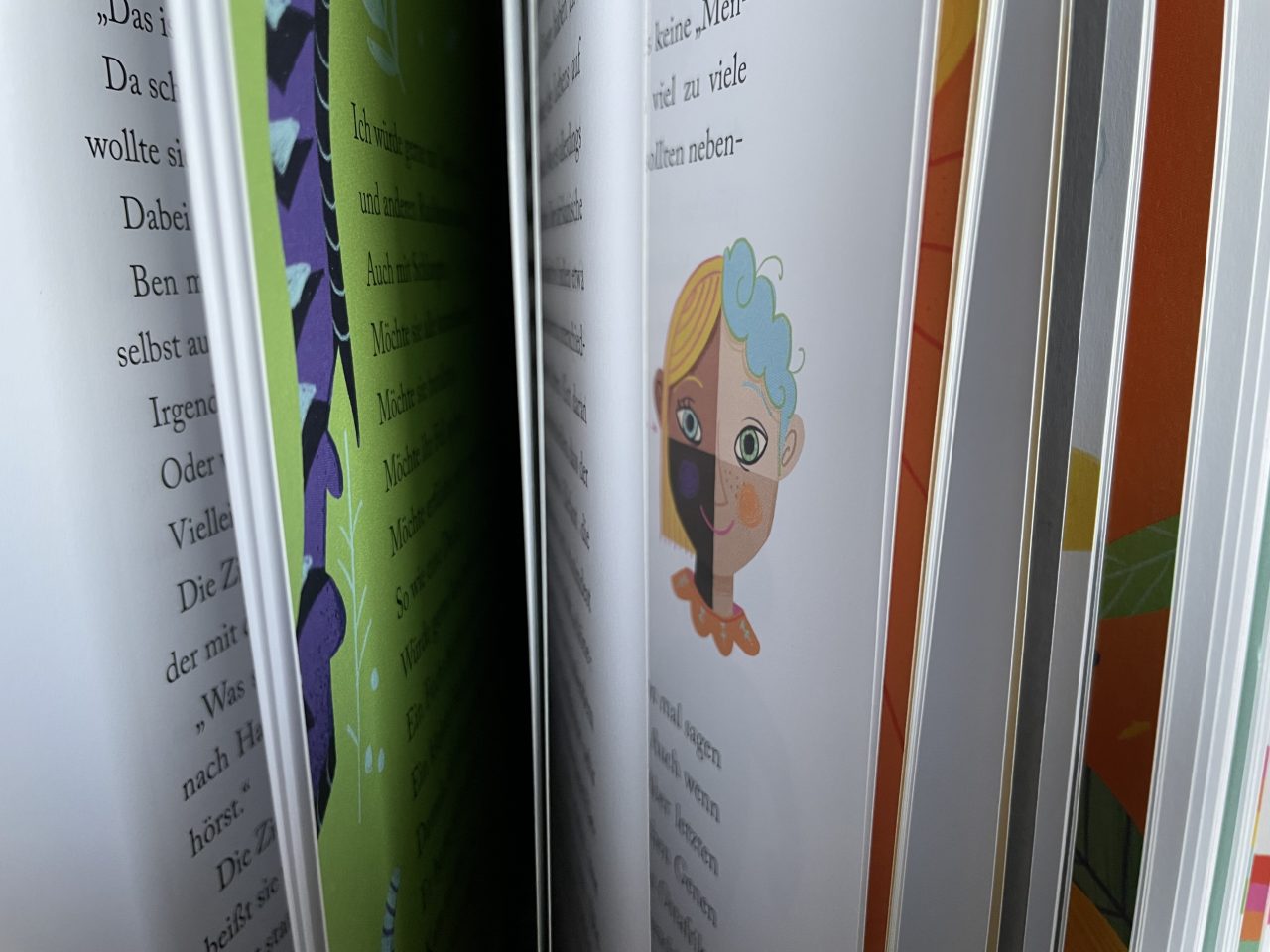 Das Kinderbuch "bunt" stehend mit aufgeblätterten Seiten