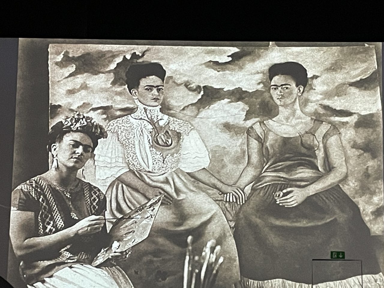 Frida Kahlo mit Malutensilien vor einem ihrer Bilder - Projektion