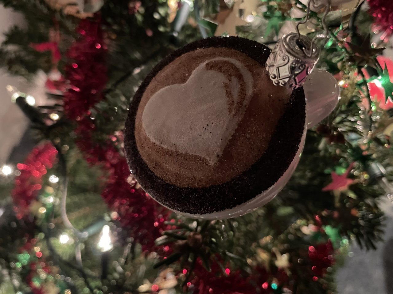 Kaffeetasse mit Latteart als Weihnachtsbaumkugel am Tannenbaum