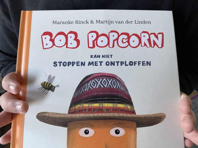 Niederländisches Bilderbuch zu Bob Popcorn von zwei Händen gehalten