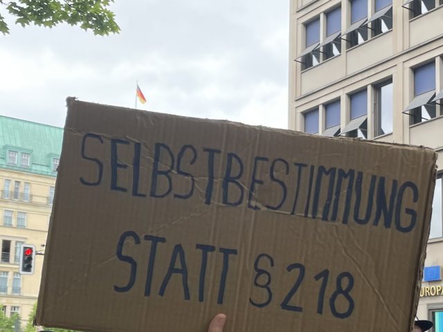 "Selbstbestimmung statt §218" auf einem Pappschild stehend bei der Demo " 100.000 Mütter"